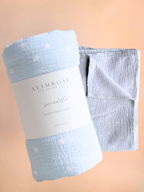 Light blue swaddle blanket with white polka dots and 'Alimrose' label on a beige background, Flowers Gold Coast